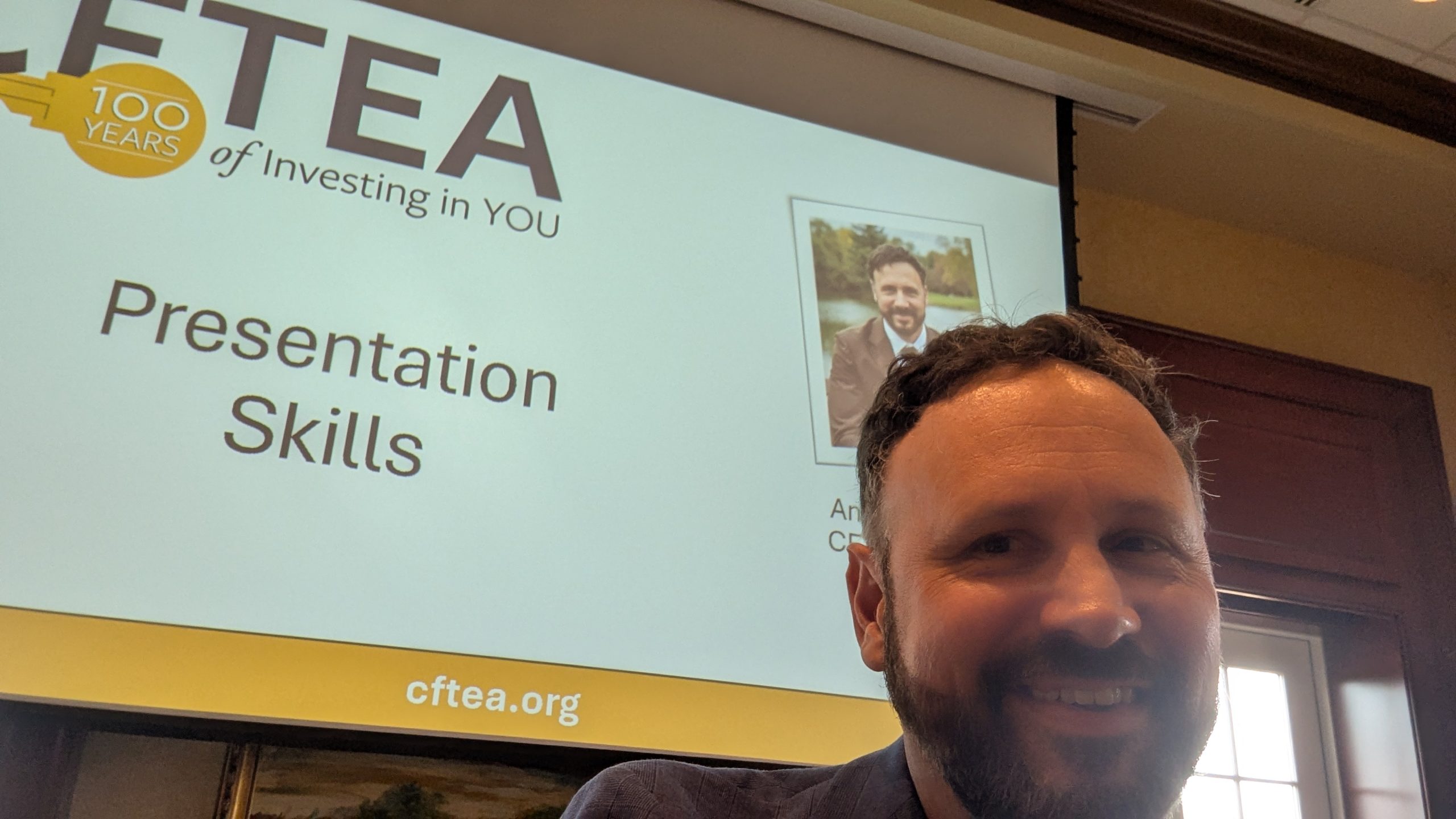 CFTEA Executive Director Andrew Lederer taking a selfie at Towne University in front of a presentation slide titled “Presentation Skills” with the CFTEA 100 Years of Investing in You logo and cftea.org displayed.