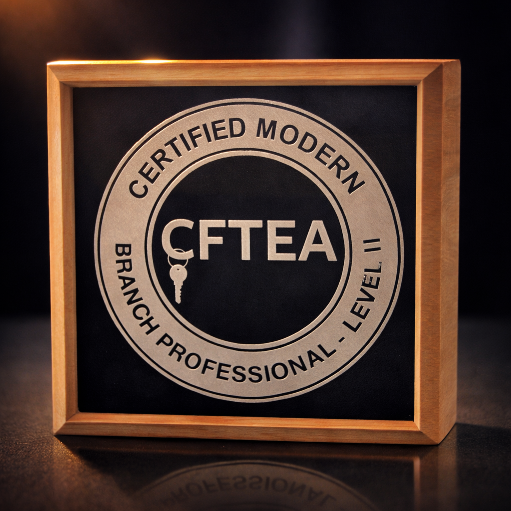 Framed CFTEA Certified Modern Branch Professional Level II award with silver lettering on a dark background and warm spotlight lighting.