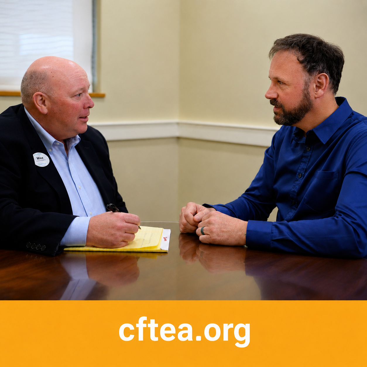 Wide banner showing two professionals seated across from each other at a conference table during a one-on-one conversation. On the left, a man in a dark blazer holds a pen over a notepad as he listens attentively. On the right, Andrew, wearing a royal blue button-down shirt, leans forward with his hands folded, maintaining focused eye contact. Their expressions convey active listening, mutual respect, and thoughtful discussion in a professional meeting setting. A gold bar spans the bottom of the image with "cftea.org" centered in white text. The image emphasizes the value of meaningful conversations, coaching, and professional relationships.